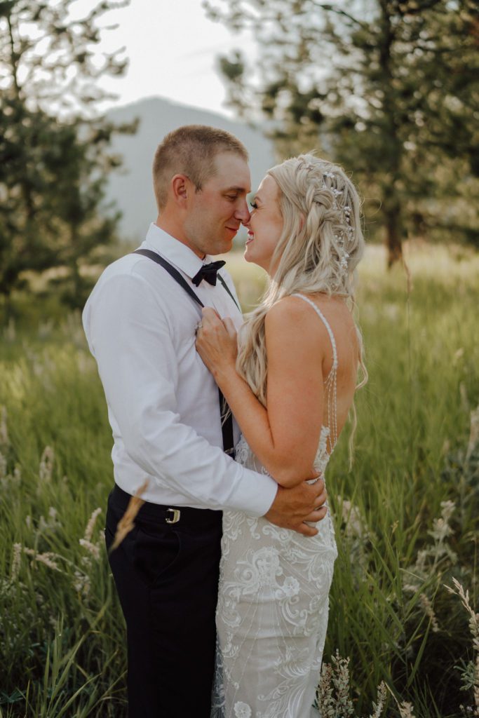 A bride and groom embrace to kiss during their Montana mountain wedding. Image by Ashley J Photo, a Montana wedding photographer.